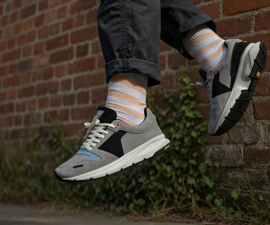A runner's legs and shoes caught mid jump beside a brick wall